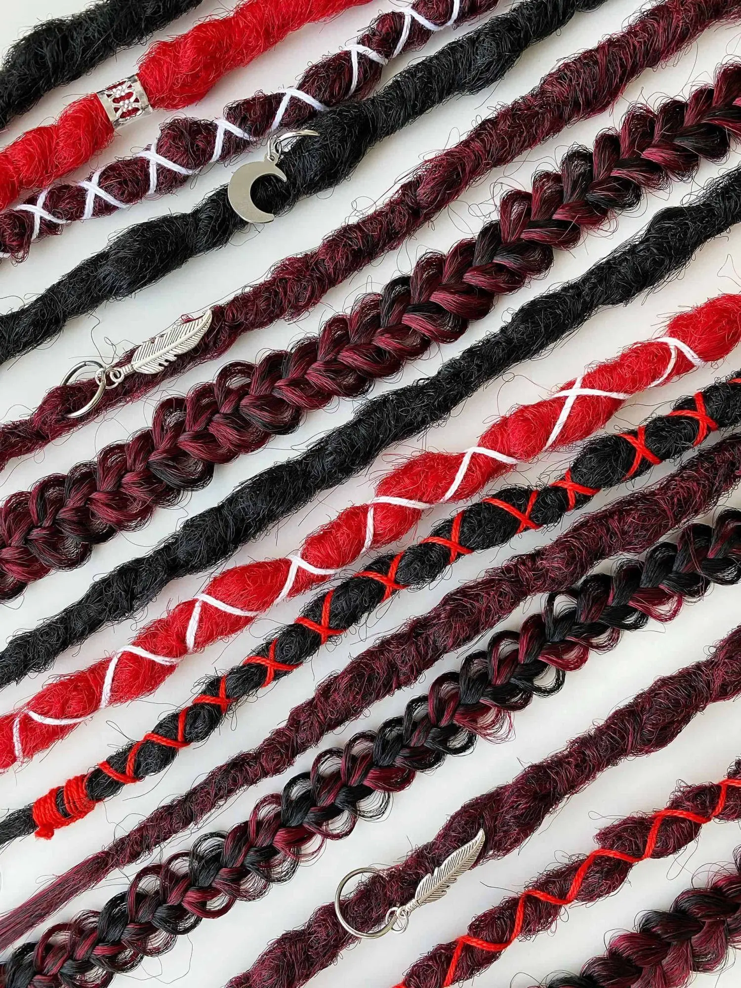 Bloodmoon kanekalon textured dreads — strand-by-strand close-up with crescent moon and feather charms