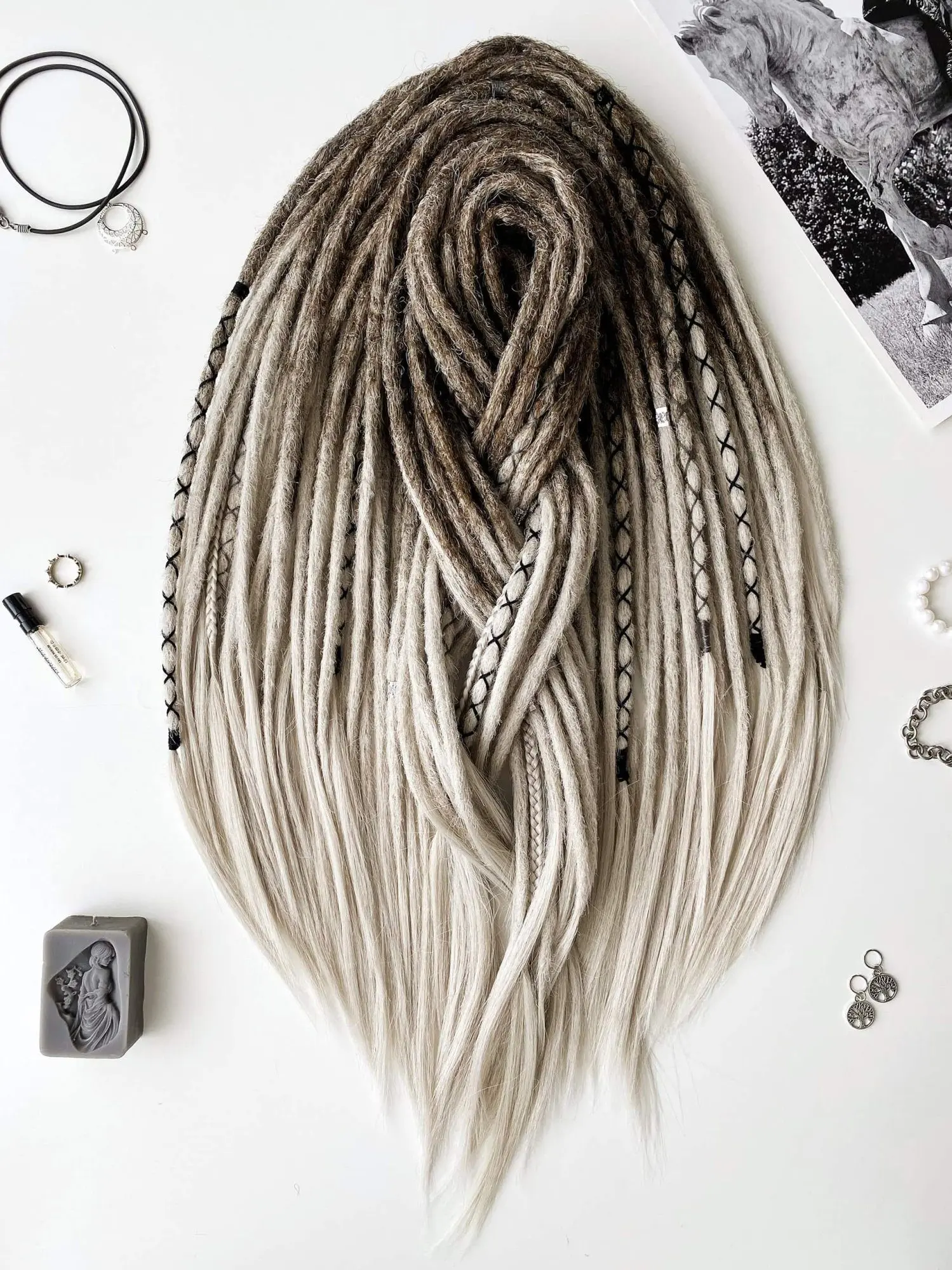 Viking ash blonde ombre synthetic dreads full set flatlay with leather pendant and silver charms