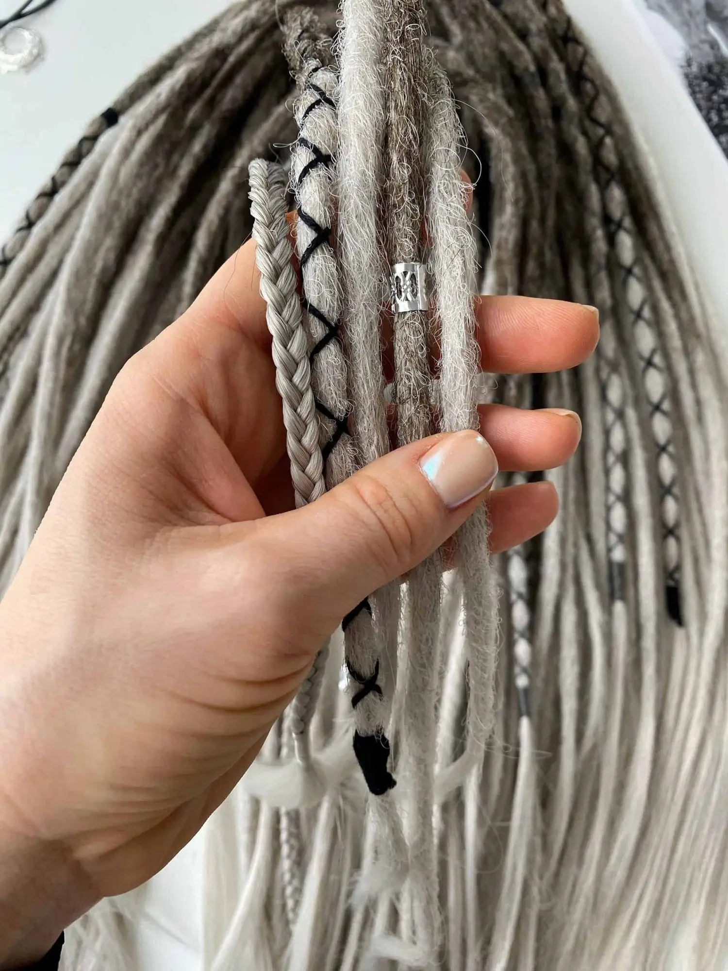 Viking smooth dread extensions close-up macro showing silver tribal cylinder bead and X-pattern thread wraps