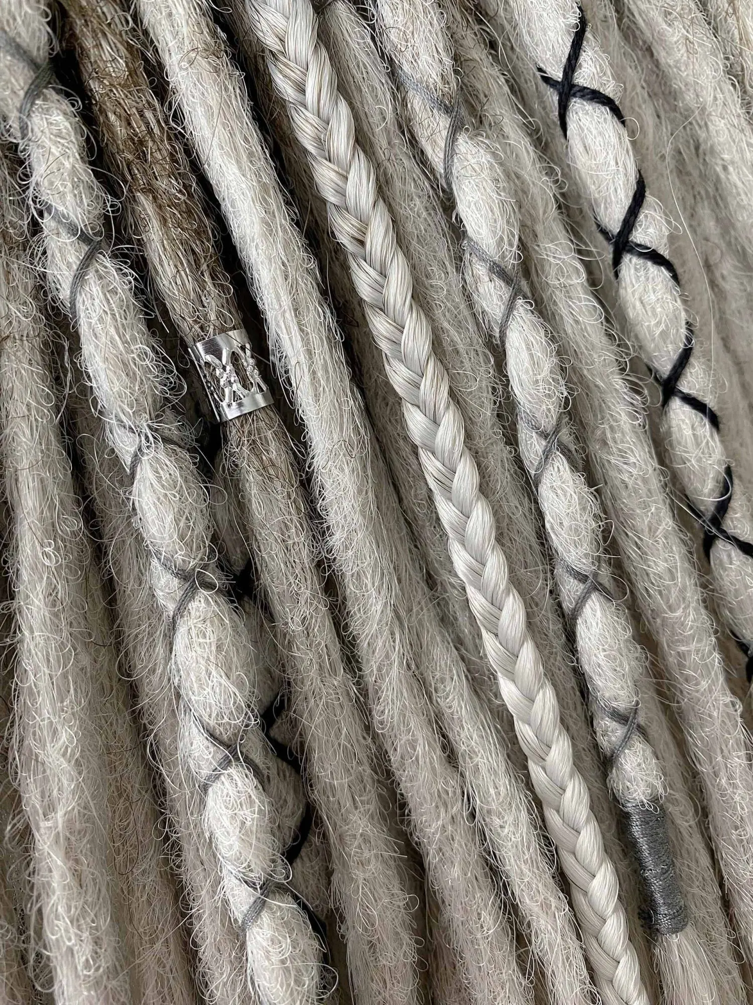 Viking smooth synthetic dreads strand-by-strand close-up showing flat braid and silver tribal bead