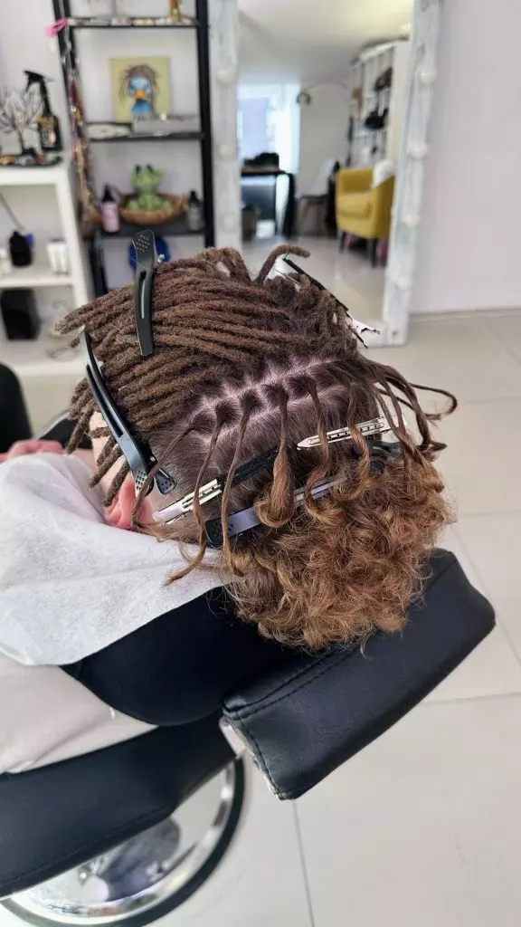 Sectioning the crown with clips while making natural dreadlocks on thick curly hair