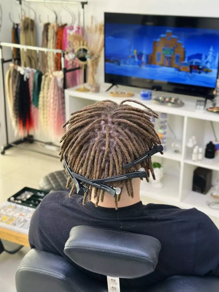 Natural dreadlocks on the crown of thick curly hair, back view