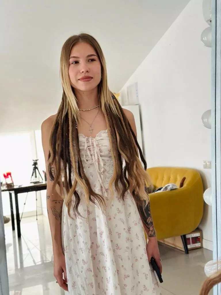 Dreadlocks partielles à l'arrière de la tête sous des cheveux blonds lâchés